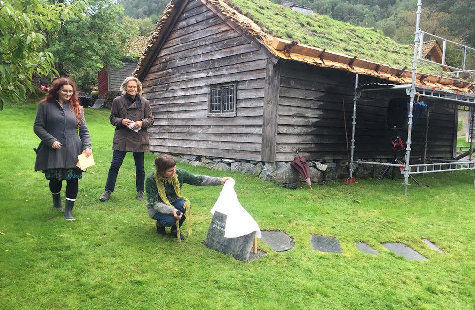 AVDUKING: Hilde Myklebust avduker si diktartavle på diktarstien i Hardanger. Bak står Agnete Sivertsen, leiar for folkemuseet, og Geir Netland, leiar for Haugesenteret.