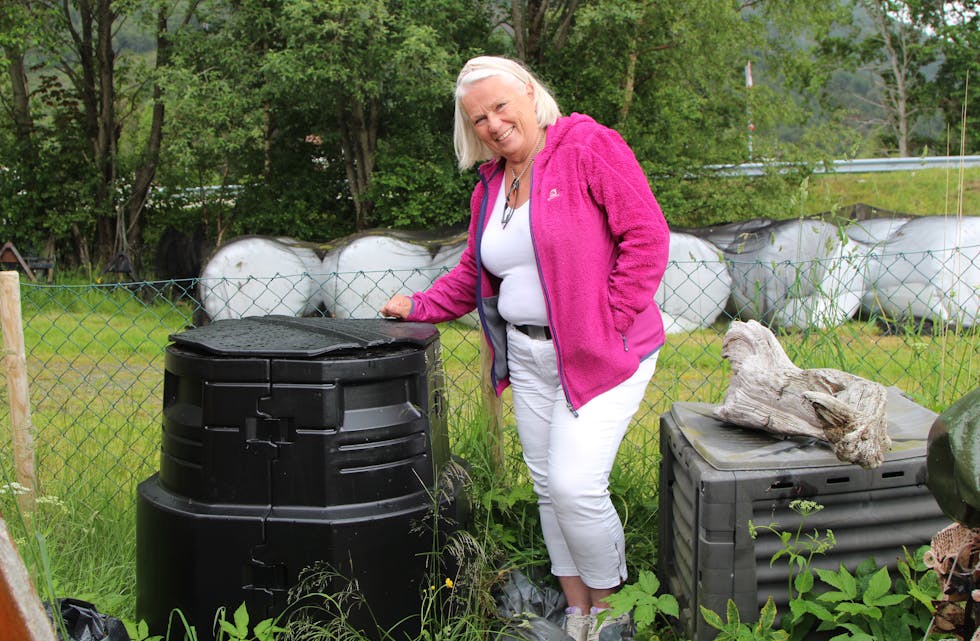 KOMPOST: Gyda Siri Kriken har både vanleg kompost i dunken til høgre og varmkompost i den ho står ved. Det gir mykje god plantejord og er ein kjekk måte å kvitte seg med organisk avfall av alle slag. 
