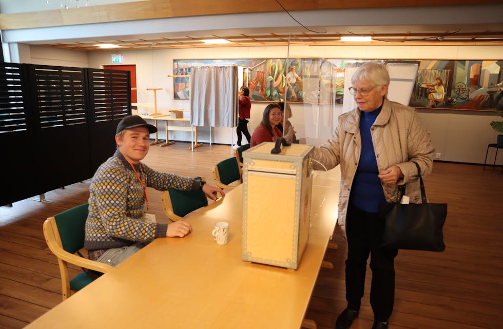 FERDIG: Arnhild Honningsvåg var ein av dei første til å legge stemmesetelen i urna på Fiskå. Håkon Brudevik og dei andre valfunksjonerane er på plass og ordnar med hjelp og registrering.