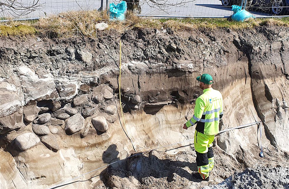 GRAVRØYS: Arkeolog Lars Jølle Berge ved eine gravrøysa som er datert tilbake til jernalderen. Her kan vi også sjå tjukke kulturlag. 