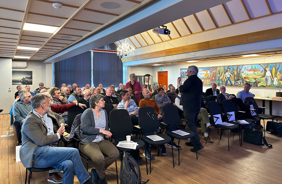 Ordførar Lena Landsverk Sande (i rosa) er ordstyrar medan Eirik Newth (med ryggen til) svarar på spørsmål om kjernekraft og debatterer med representantar i salen.