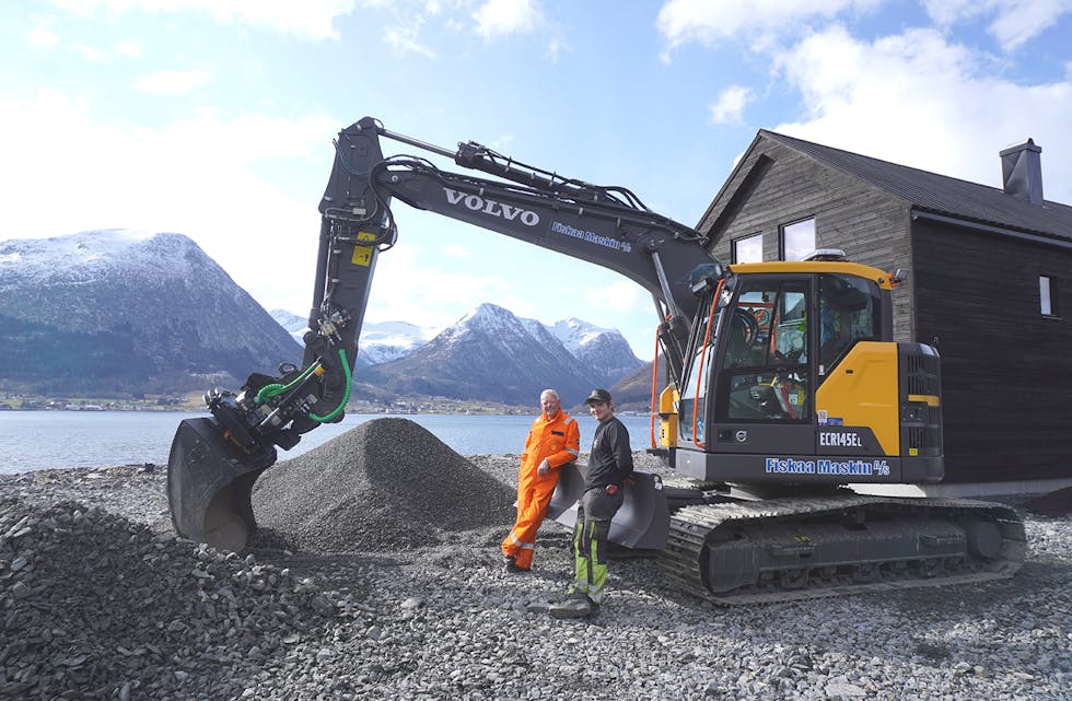 STORE VERKTY: Oddvar Strand og Adrian Fiskaa jobbar på med uteområdet rundt fritidsbustadane på Hatleneset, men vi ser klart kven som har handa på rattet i prosjektet no. I den store gravemaskinen som Adrian har adriftsansvar for ligg arbeidsteikningane, og når vi kjem til staden hoppar han ut av gravemaskinen og tek til jarnriva for å jamne ut massane han har lagt på plass, før han tek praten med oss.