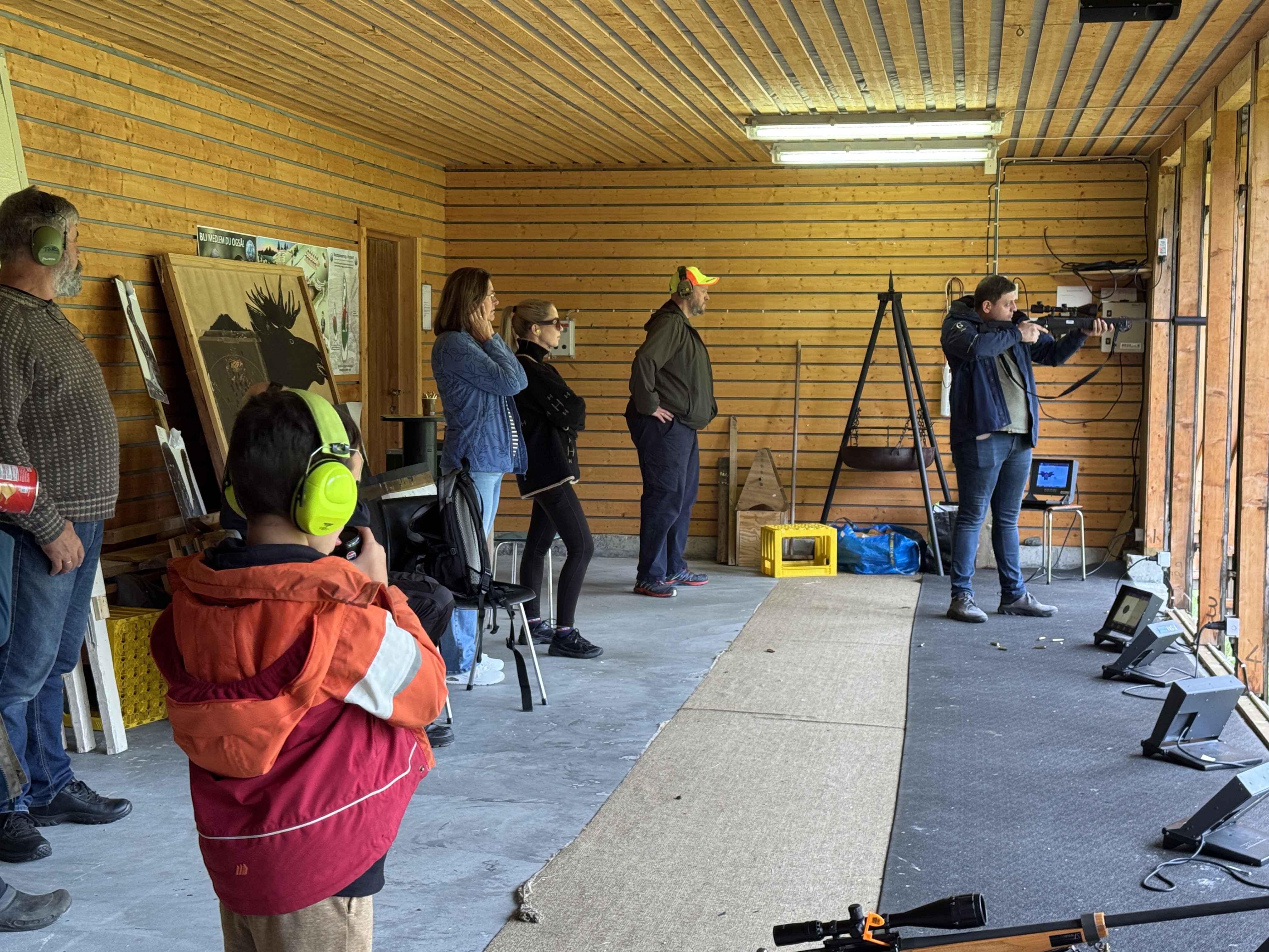 SKYTINGENS DAG: Gode instruksjonar frå erfarne, og på med høyreklokkene for tilskodarane. Her er det Martin Ulla som prøver seg på den bevegelege elgen på bana til Vanylven jakt- og fiskeforening. – Her vart det elgbiff til middag, kommenterte Aksel Øren (i gul caps) til Ulla etterpå.